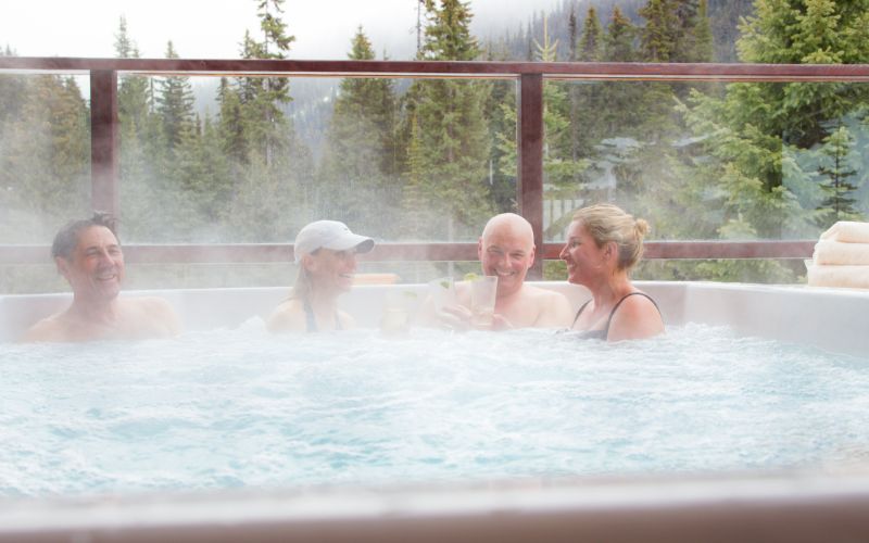heli-skiing-cariboos-lodge-friends-relaxing-in-a-hot-tub-min
