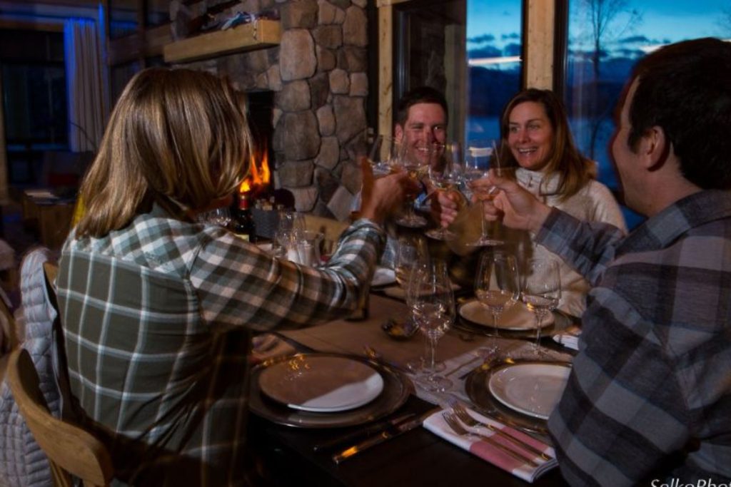 helicopter-skiing-group-enjoys-drinks-and-a-meal-min
