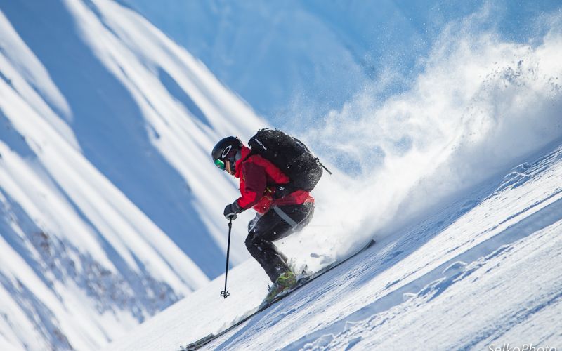 helicopter-skiing-skier-heading-down-mountainside-min