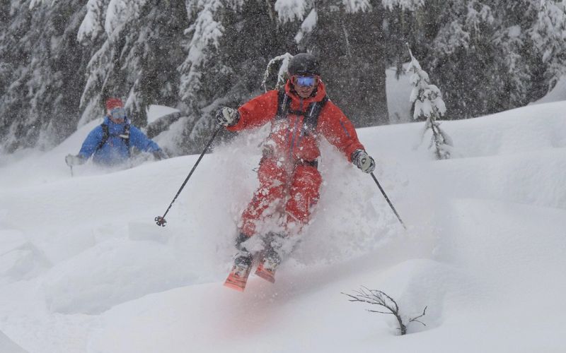 helicopter-skiing-two-skiers-deep-snow-min