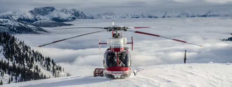 heli-skiing-canada-chopper-on-peak-min