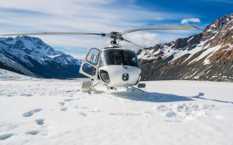 heli-skiing-canada-helicopter-landing-on-a-snow-mountain-min