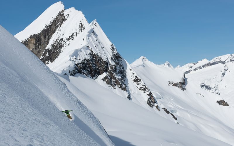 heli-skiing-canada-skiers-on-steep-descent-min