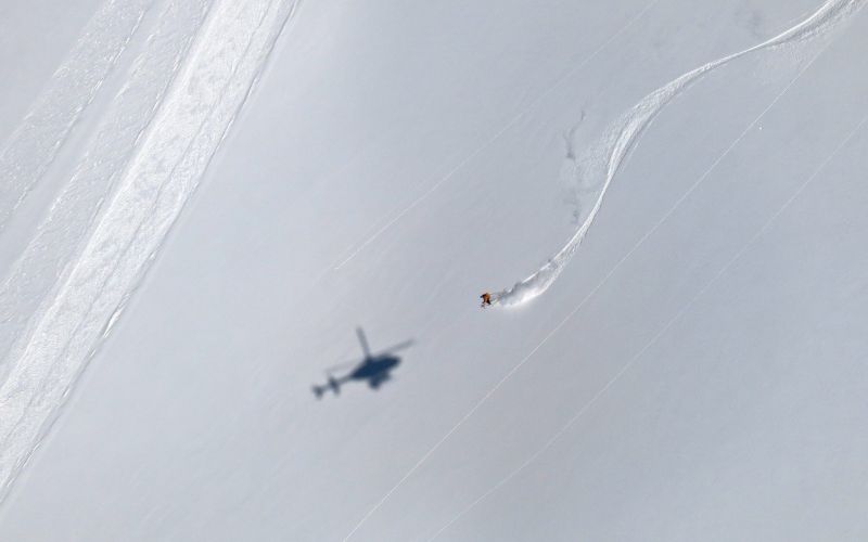 heli-skiing-canada-skier-with-helicopter-shadow-min