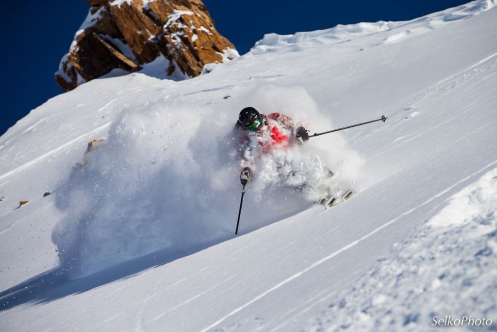 heli-skiing-skier-deep-powder-min