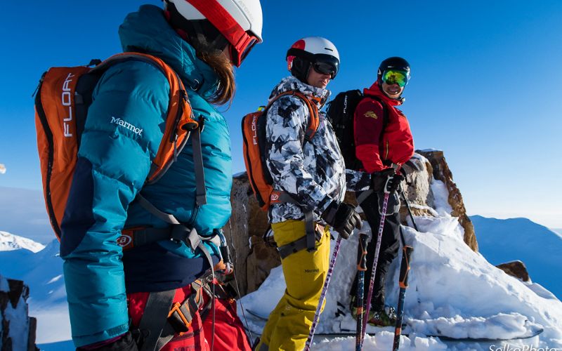 heli-skiing-three-skiers-on-peak-min